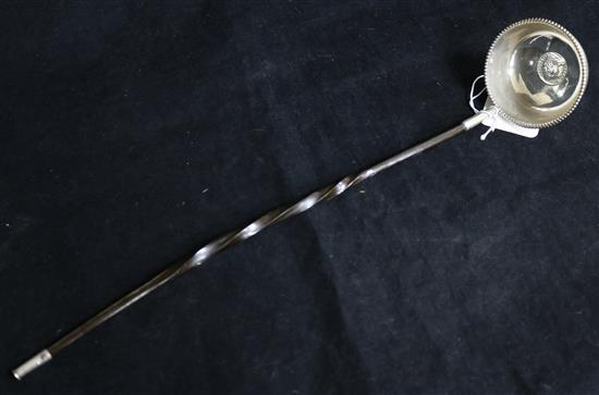 An 18th century white metal toddy ladle, with inset coin bowl and baleen handle, 36.6cm.